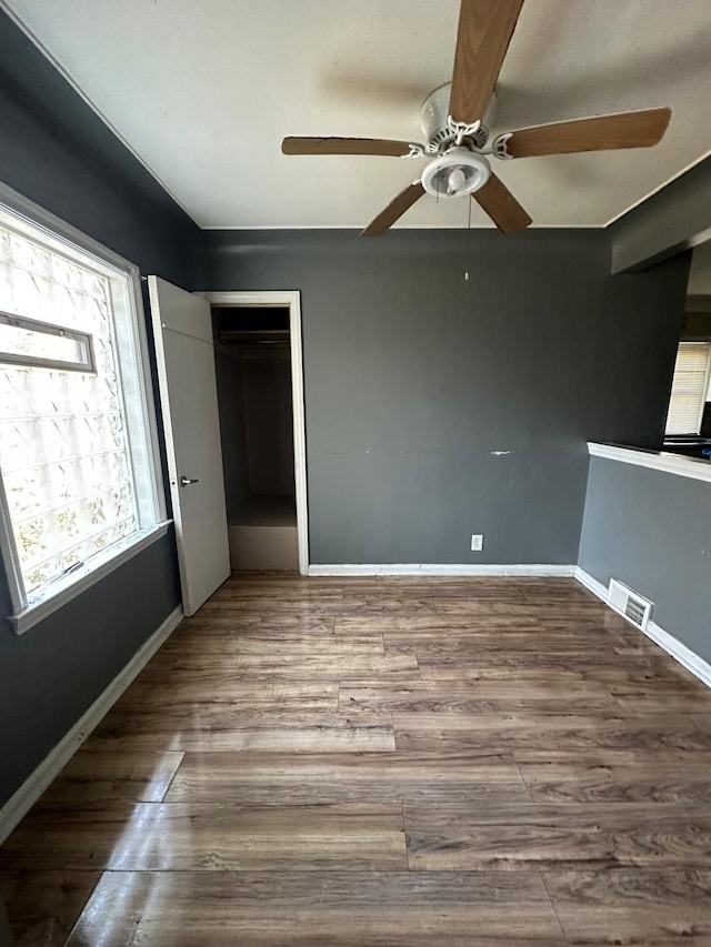 unfurnished bedroom with ceiling fan, wood-type flooring, and a closet