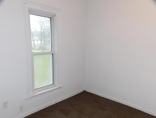 138 E Euclid Ave, Jackson, MI 49203 - spare room with dark carpet, healthy amount of natural light, and baseboards