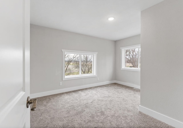 carpeted spare room featuring a wealth of natural light