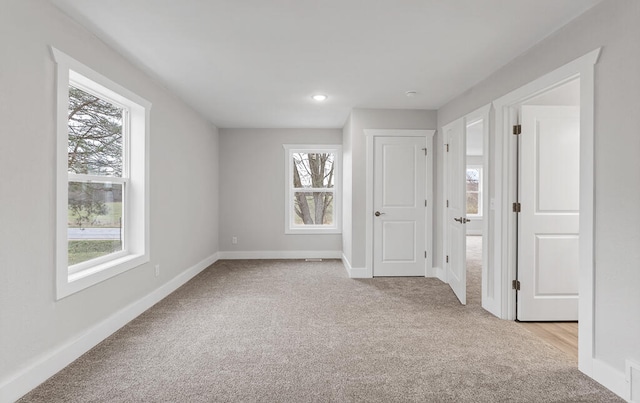 carpeted empty room featuring a wealth of natural light