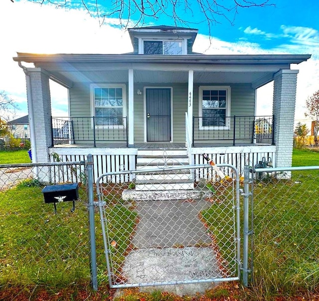 bungalow-style house featuring covered porch and a front lawn