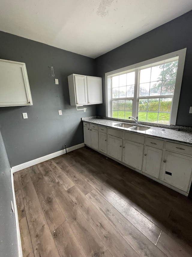 kitchen with white cabinets, wood-type flooring, and sink