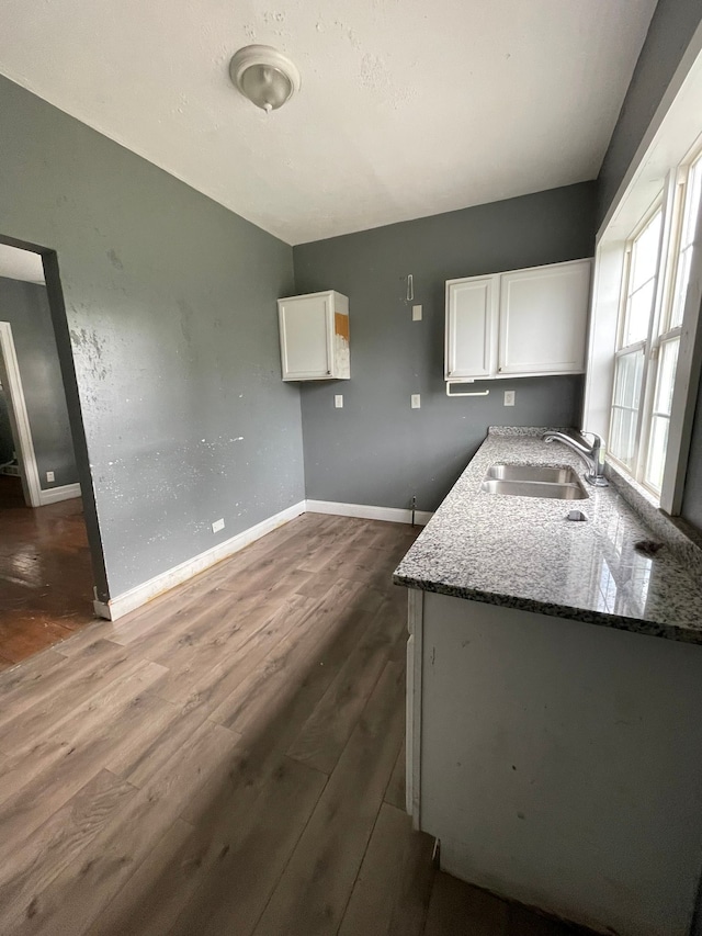 kitchen featuring stone countertops, dark hardwood / wood-style floors, white cabinetry, and sink