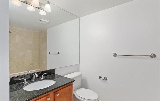 bathroom with a shower, vanity, and toilet