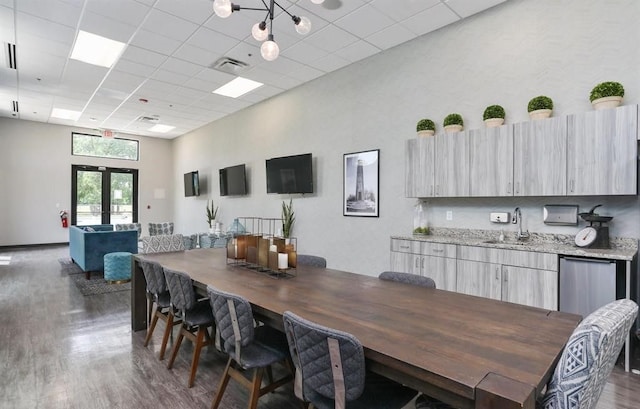 dining room with a drop ceiling, dark hardwood / wood-style flooring, sink, and french doors