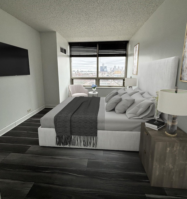 bedroom featuring dark hardwood / wood-style floors, a wall of windows, and a textured ceiling