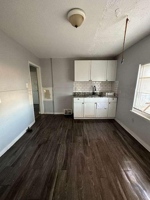 kitchen with dark hardwood / wood-style floors, white cabinetry, and a textured ceiling