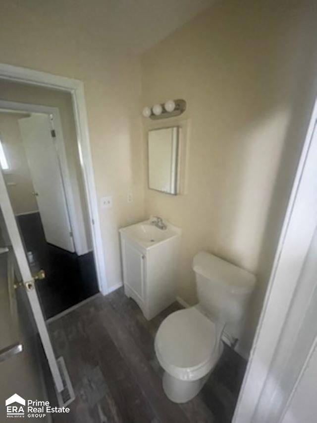 bathroom with hardwood / wood-style flooring, vanity, and toilet