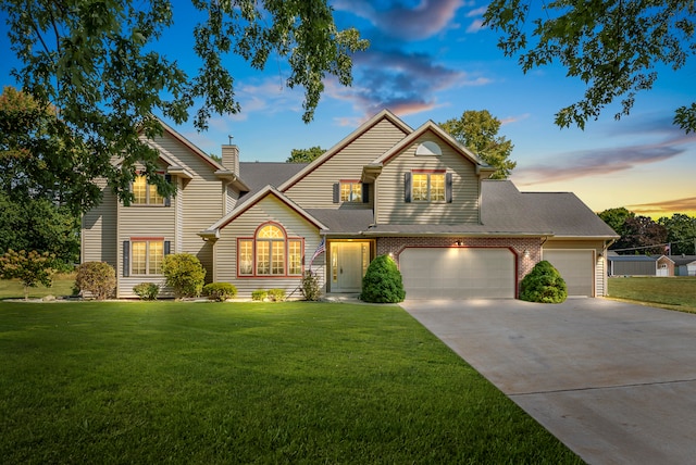 view of property with a garage and a lawn