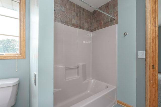 bathroom featuring shower / tub combination and toilet