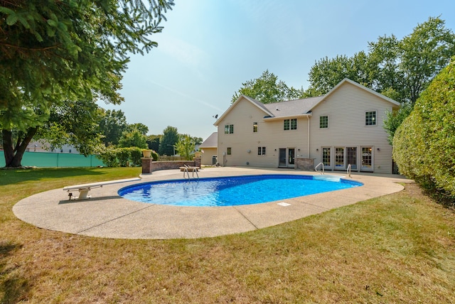 view of pool featuring a yard, a diving board, a patio area, and french doors