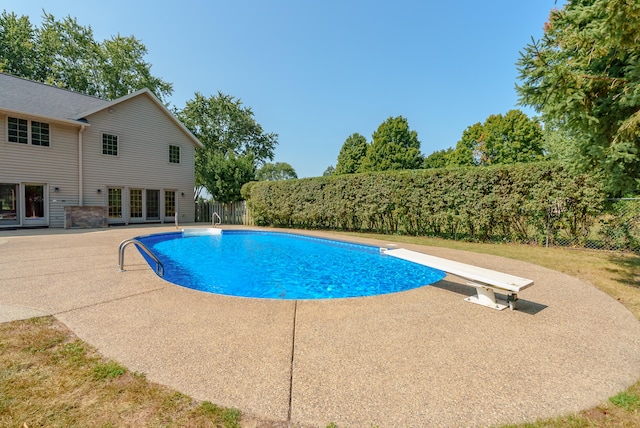 view of pool featuring a diving board and a patio area