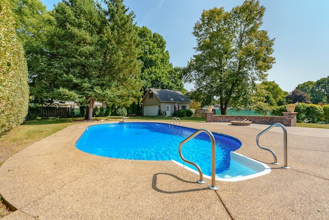 view of swimming pool featuring an outbuilding and a patio area