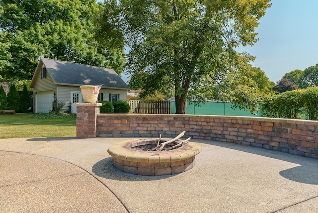 view of patio with an outbuilding, a garage, and a fire pit