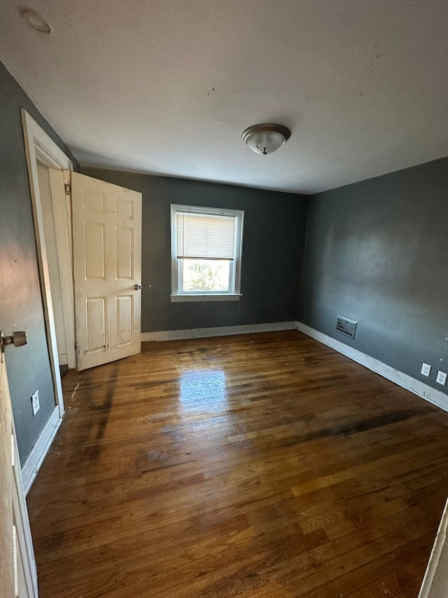 unfurnished room featuring a textured ceiling and dark hardwood / wood-style floors