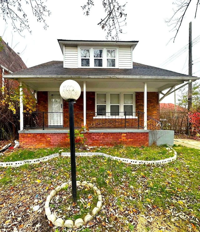 view of front of home with covered porch and a front yard