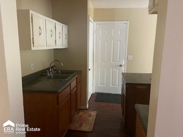 kitchen featuring dark hardwood / wood-style flooring, white cabinetry, and sink