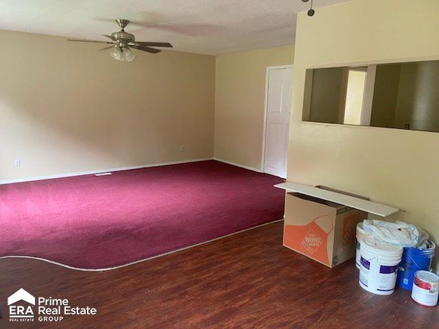 empty room featuring ceiling fan and dark wood-type flooring