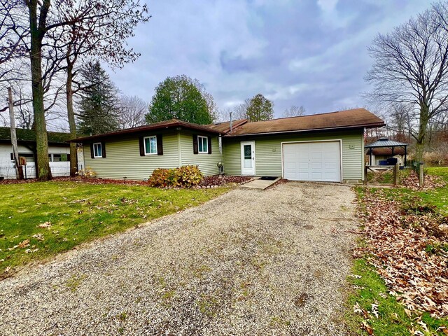 5376 Circle Dr, Reading, MI 49274 - ranch-style house featuring a garage, gravel driveway, a gazebo, and a front yard