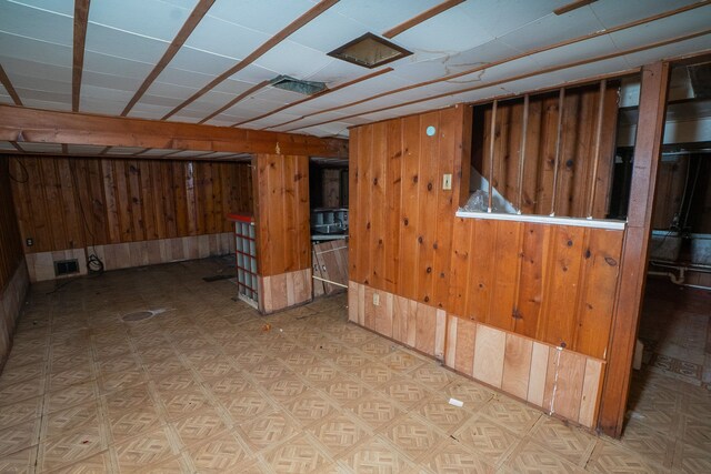 basement featuring wooden walls