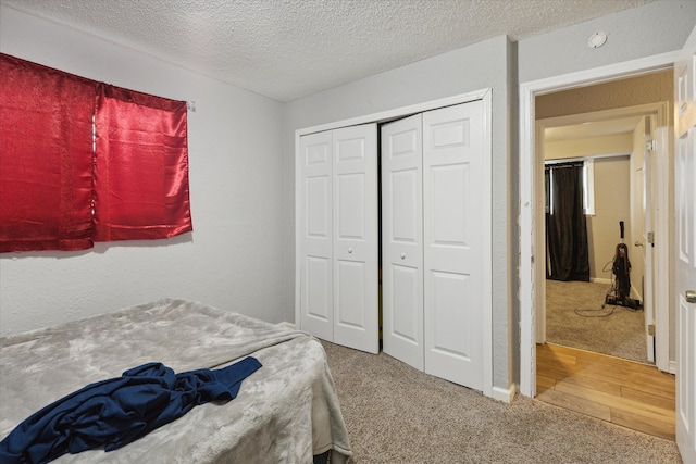 bedroom featuring carpet flooring, a closet, and a textured ceiling