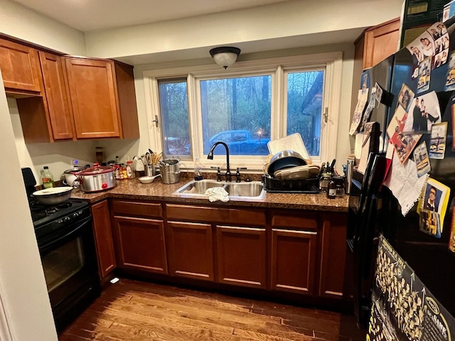 kitchen featuring dark hardwood / wood-style flooring, sink, and black appliances