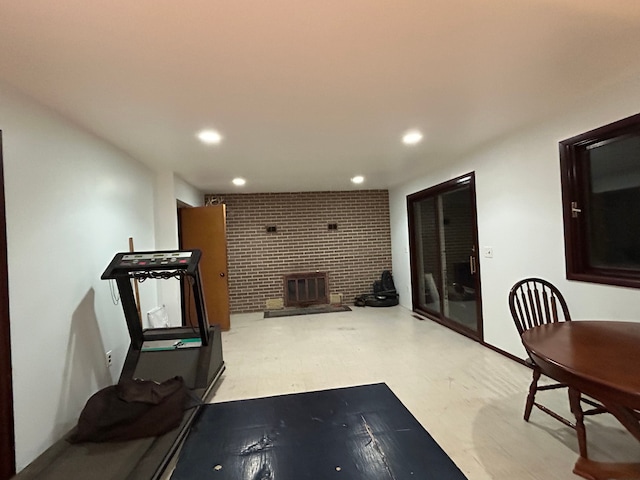 exercise room featuring a wood stove and brick wall