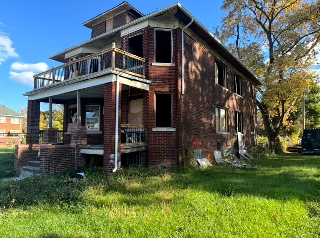 exterior space with a balcony and a front yard