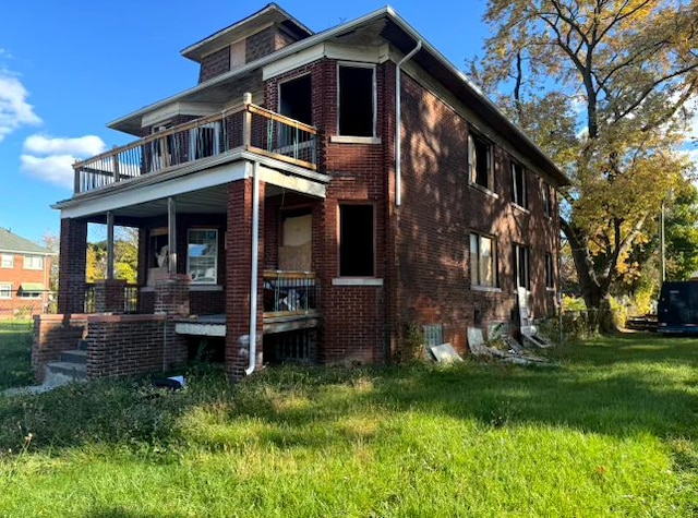 exterior space with a balcony and a front yard