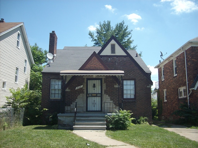 14564 Terry St, Detroit, MI 48227 - tudor home featuring brick siding, a chimney, and a front yard