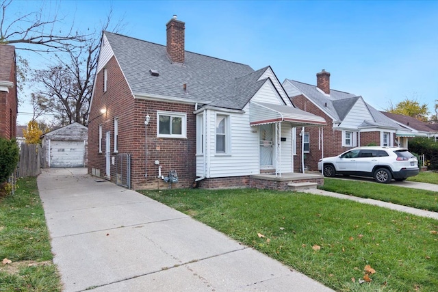 bungalow-style house with a front yard, an outdoor structure, and a garage