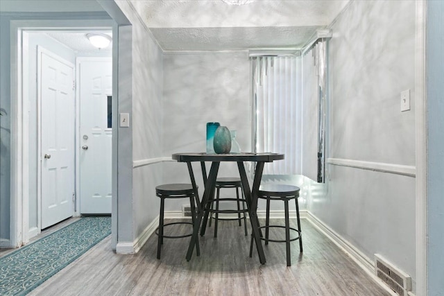 dining area featuring hardwood / wood-style floors and a textured ceiling