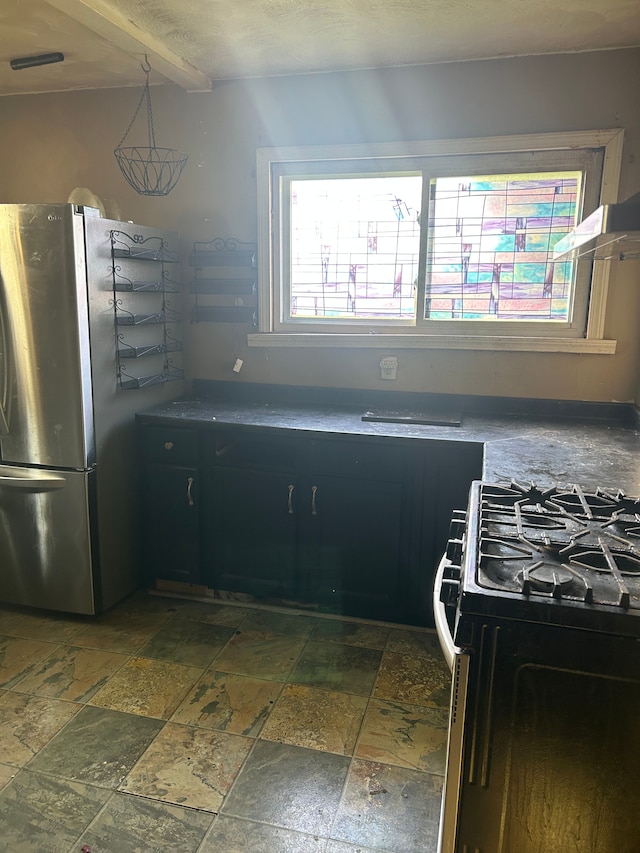 kitchen with stainless steel fridge, black gas stove, and beam ceiling