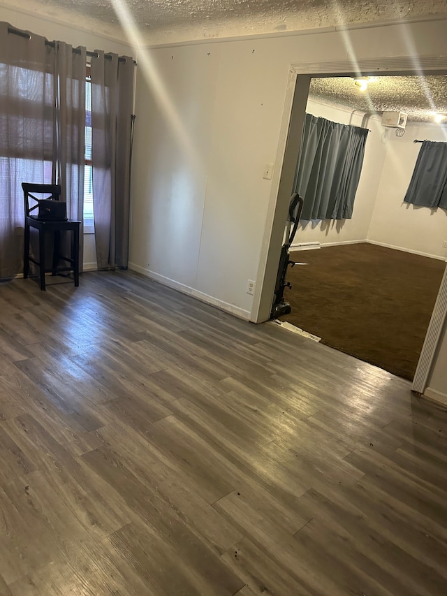 empty room with dark hardwood / wood-style flooring and a textured ceiling