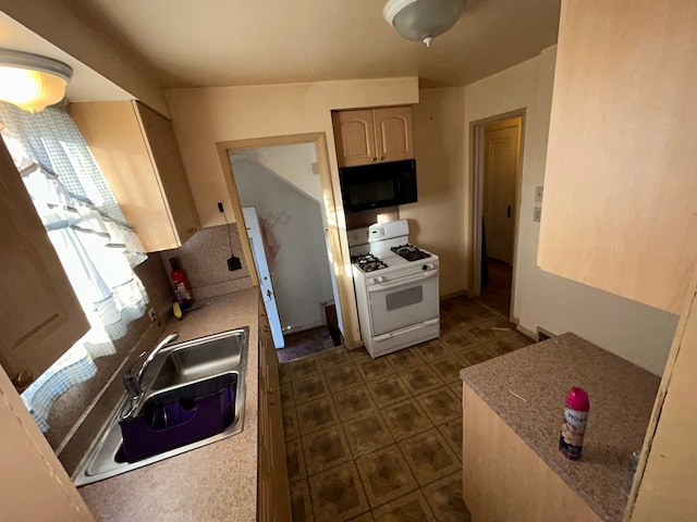 kitchen with sink, light brown cabinetry, and white gas range oven