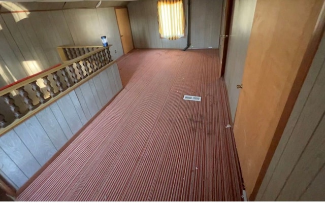 interior space with carpet and wooden walls