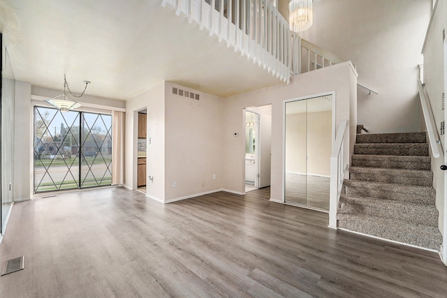 unfurnished living room with hardwood / wood-style floors and an inviting chandelier