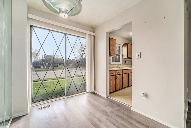 unfurnished dining area featuring light hardwood / wood-style flooring and sink