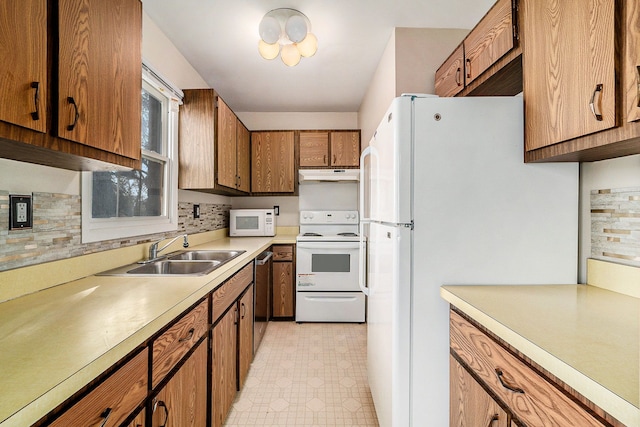 kitchen featuring backsplash, white appliances, and sink