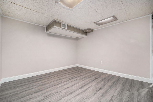 unfurnished room featuring wood-type flooring and a paneled ceiling