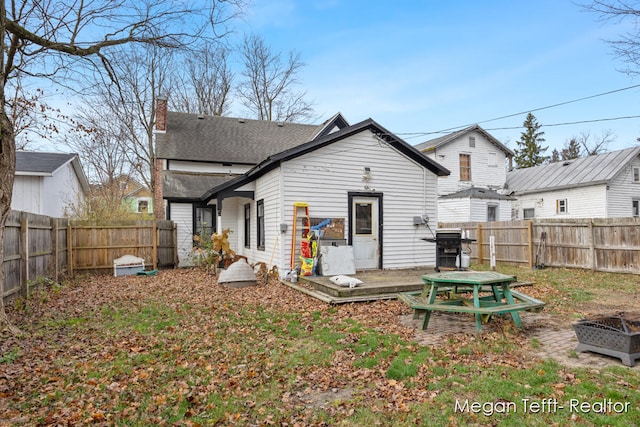 rear view of property featuring a deck and an outdoor fire pit