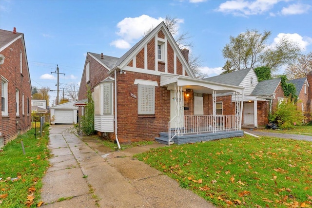 view of front of home with a porch, a front lawn, an outdoor structure, and a garage