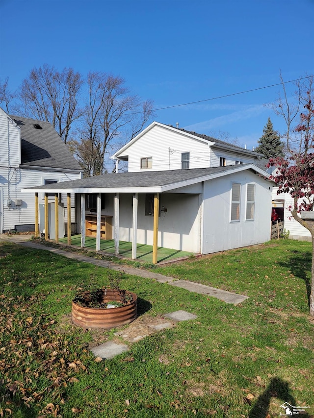 rear view of house featuring a yard