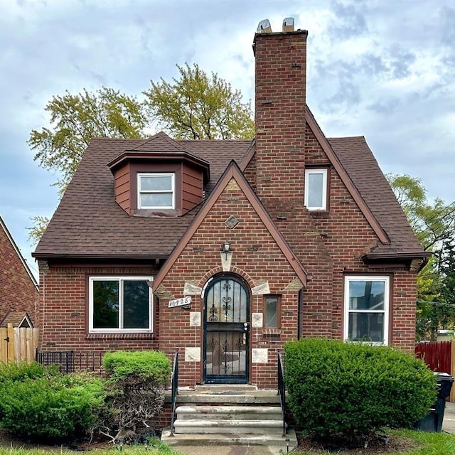 10728 Worden St, Detroit, MI 48224 - english style home featuring brick siding, a chimney, and a shingled roof