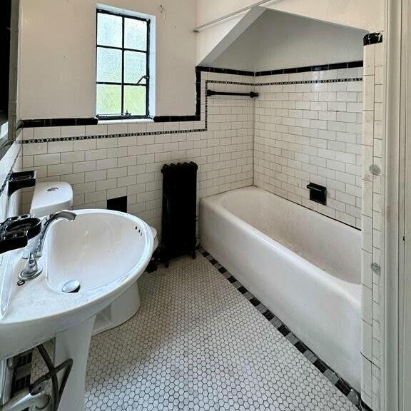 10728 Worden St, Detroit, MI 48224 - full bathroom with wainscoting, tile walls, and tile patterned flooring