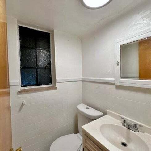 10728 Worden St, Detroit, MI 48224 - half bath with tile walls, toilet, and vanity