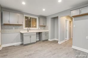 5200 Haverhill St, Detroit, MI 48224 - kitchen featuring gray cabinetry, baseboards, light wood-type flooring, a sink, and recessed lighting