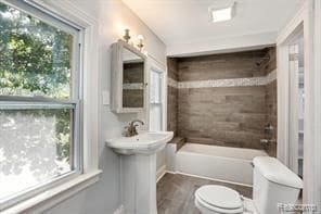 5200 Haverhill St, Detroit, MI 48224 - bathroom with toilet, a tub, and wood finished floors