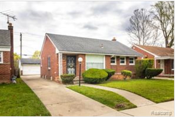 view of front of house featuring a garage, an outdoor structure, and a front yard