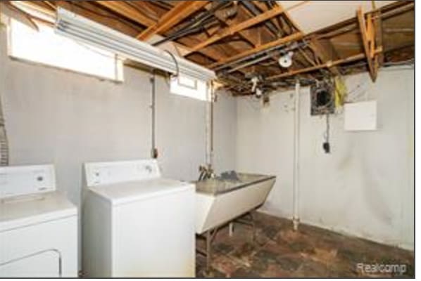 washroom with independent washer and dryer and sink